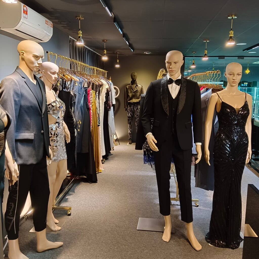 Mannequins dressed in designer suits and elegant evening gowns at Shingary Diamonia, showcasing a range of luxury fashion items, including formalwear and glamorous dresses.