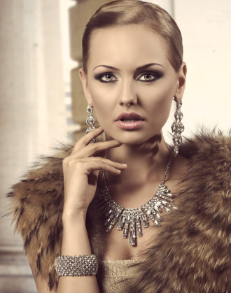 Elegant woman wearing a fur stole paired with a dazzling diamond necklace, earrings, and bracelet, set against a backdrop of classical architecture, showcasing high-end fashion and sophistication.